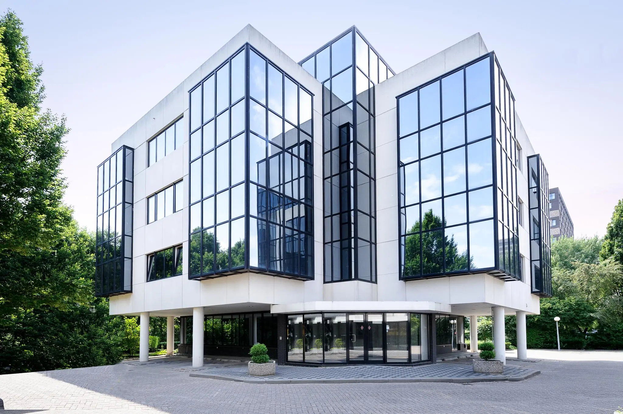 Modern kantoorgebouw aan de Max Euwelaan met grote glazen gevels en witte betonelementen.